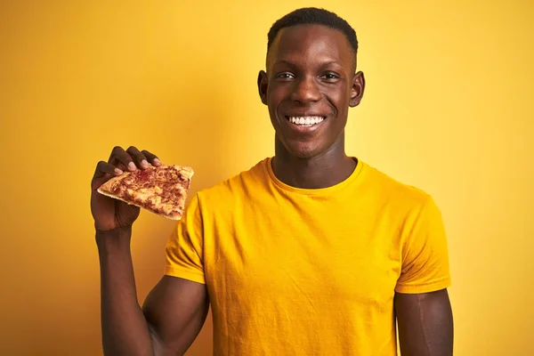 African American Man Jedzenia Kawałek Pizzy Stoi Białym Tle Żółtym — Zdjęcie stockowe