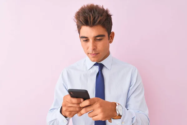 Молодой Красивый Бизнесмен Используя Смартфон Стоящий Изолированном Розовом Фоне Уверенным — стоковое фото