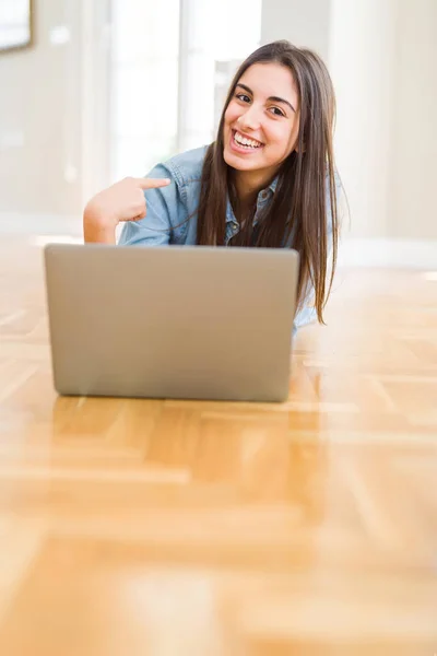 Mulher Bonita Deitado Chão Usando Laptop Com Rosto Surpresa Apontando — Fotografia de Stock