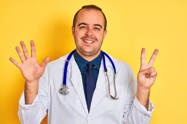 Joven Doctor Hombre Usando Abrigo Estetoscopio Pie Sobre Fondo Amarillo — Foto de Stock