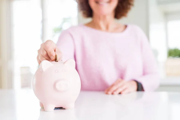 Primer plano de la mujer mayor poniendo una moneda dentro de la alcancía como sav — Foto de Stock