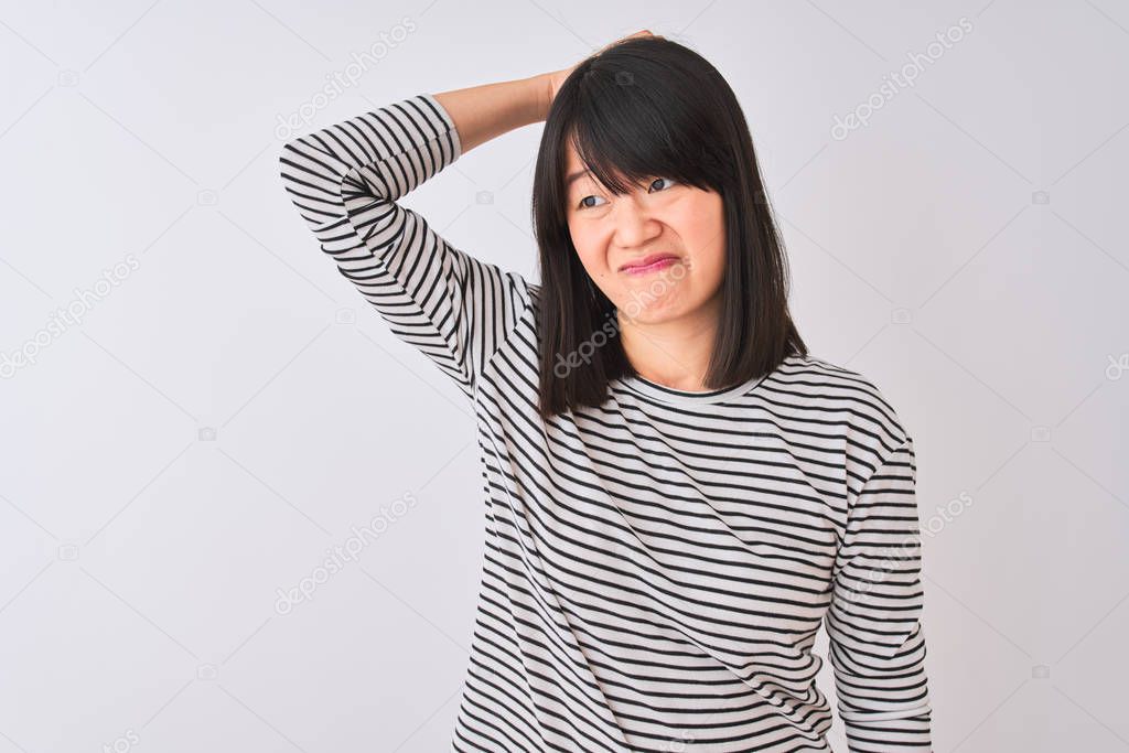 Young beautiful chinese woman wearing black striped t-shirt over isolated white background confuse and wonder about question. Uncertain with doubt, thinking with hand on head. Pensive concept.
