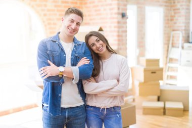 Yeni bir eve taşınan genç çift mutlu bir yüz kameraya bakarak çapraz kolları ile gülümseyerek. Pozitif kişi.