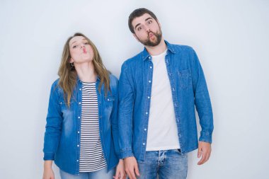 Genç güzel çift dudakları, çılgın ve komik jest ile balık yüz yapma beyaz izole arka plan üzerinde birlikte ayakta. Komik ifade.