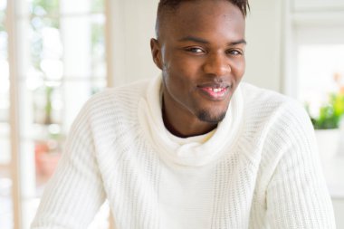 Gülümseyen yüzünde kocaman bir gülümseme ile neşeli Afrika yakışıklı genç