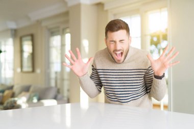 Genç yakışıklı adam evde deli ve çığlık kaldırdı ve kapalı gözleri heyecanlı silah ile başarı için deli kutluyor. Kazanan kavramı