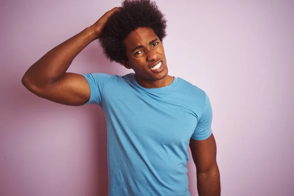 非洲裔美国男子与非洲头发穿着蓝色T恤站在孤立的粉红色背景混淆和怀疑的问题 不确定与怀疑 用手在头上思考 沉思概念 — 图库照片