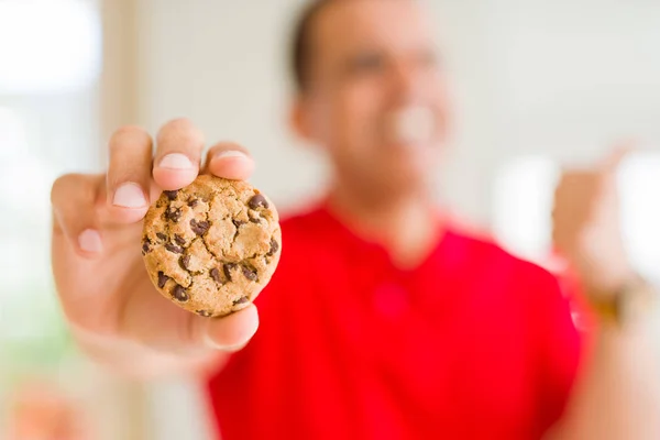 Homem Meia Idade Comendo Biscoitos Chocolate Casa Apontando Mostrando Com — Fotografia de Stock