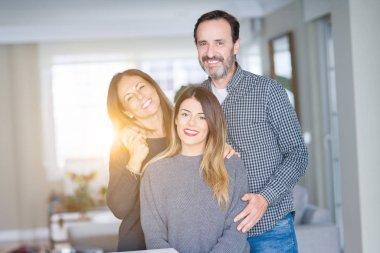 Güzel aile birlikte. Anne, baba ve kızı gülümseyen ve evde sevgi ile sarılma.
