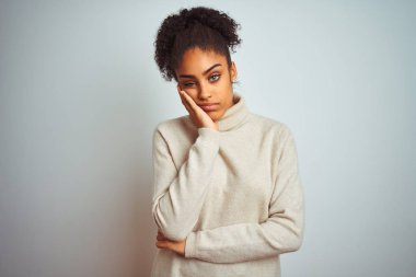 Izole beyaz arka plan üzerinde kış balıkçı yaka kazak giyen Afrikalı-Amerikalı kadın yorgun görünümlü ve çapraz kolları ile depresyon sorunları ile sıkılmış düşünme.
