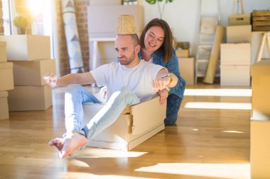 Komik ve çılgın çift bir araba olarak bir cardboad kutusu sürme eğlenceli sahip, mutlu gülümseyen ve yeni evde gülüyorsun