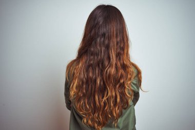 Yeşil gömlek giyen genç güzel kadın çapraz kolları ile geriye doğru duran gri izole arka plan üzerinde duran