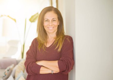 Evde Çapraz kollar ile gülümseyen güzel orta yaş kadın