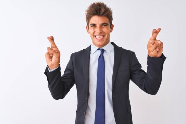 İzole beyaz arka plan gesturing parmak üzerinde duran takım elbise giyen genç yakışıklı işadamı umut ve gözleri kapalı gülümseyerek geçti. Şans ve batıl kavram.