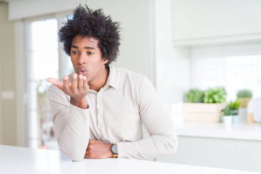 Afrika kökenli Amerikalı adam evde bir öpücük el ile güzel ve seksi olmak hava üfleme kamera bakıyor. Aşk ifade.