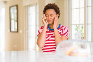 Genç güzel afro-amerikan kadın evde eliyle baş ağrısı için stres çünkü. Acı çeken migren.