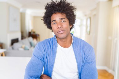 Yüzünde ciddi bir ifade ile Afrika kökenli Amerikalı adam evde rahat. Basit ve çapraz silah ile doğal