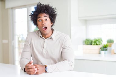 Afrika kökenli Amerikalı adam evde korkuyor ve sürpriz ifade ile şok korku ve yüz heyecanlı.