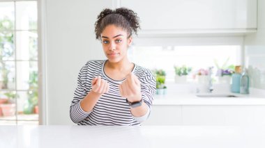 Afro saçlı güzel afro-amerikan kadın rahat çizgili kazak giyen elleriyle para jest yapıyor, maaş ödeme isteyen, milyoner iş