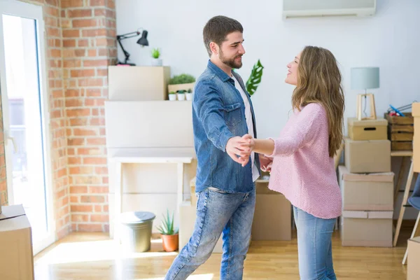 Pareja joven bailando celebrando mudarse a un nuevo apartamento alrededor —  Fotos de Stock