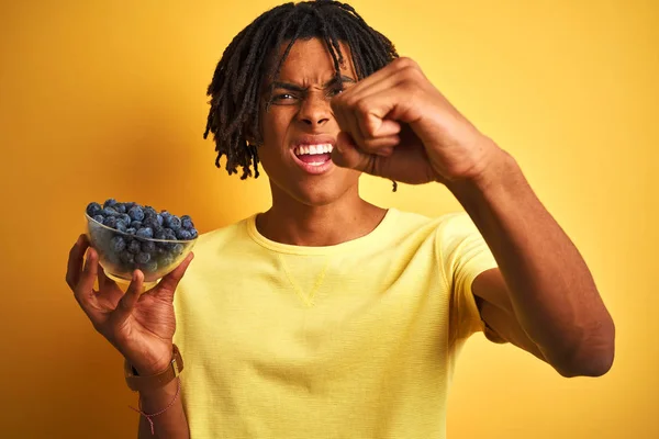 Hombre Afroamericano Con Rastas Sosteniendo Arándanos Sobre Fondo Amarillo Aislado — Foto de Stock