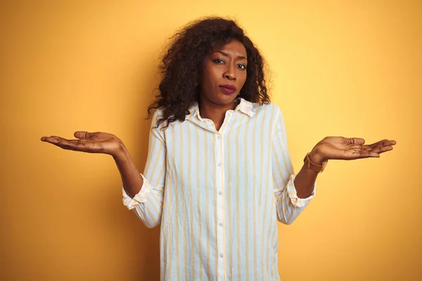 Африканская Американка Полосатой Рубашке Стоящая Изолированном Желтом Фоне Ничего Понимающая — стоковое фото