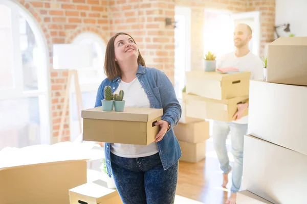 Pareja Joven Mudándose Nuevo Hogar Sonriendo Feliz Sosteniendo Cajas Cartón — Foto de Stock