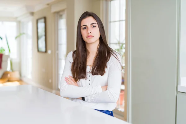 Mulher Bonita Sentada Mesa Branca Casa Cética Nervosa Desaprovando Expressão — Fotografia de Stock