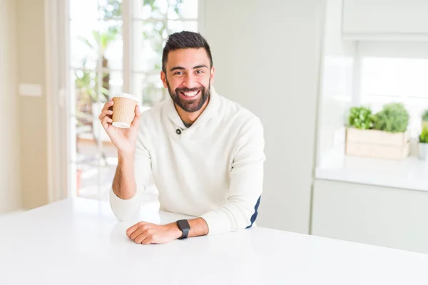 Hombre guapo sonriendo mientras disfruta bebiendo un café para llevar — Foto de Stock