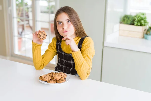 Menina Bonita Criança Comendo Chips Chocolate Biscoitos Rosto Sério Pensando — Fotografia de Stock