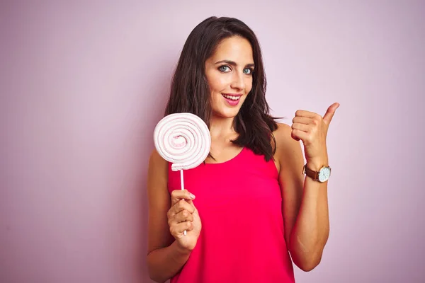 Young Beautiful Woman Eating Sweet Candy Pink Isolated Background Pointing — Stock Photo, Image