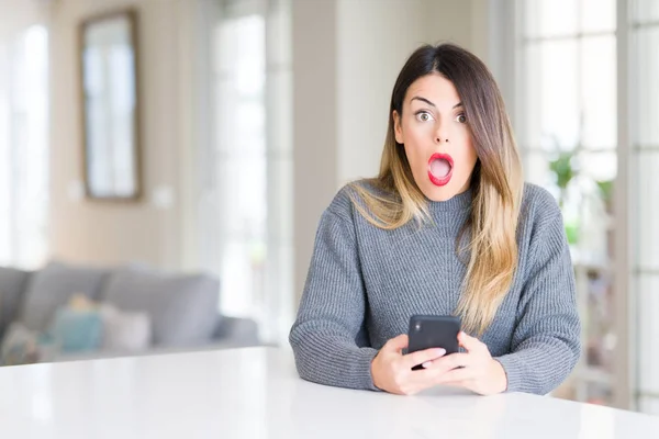 Jovem Mulher Bonita Usando Smartphone Casa Assustada Choque Com Rosto — Fotografia de Stock