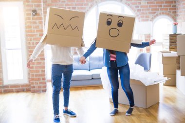 Çılgın çift kafa üzerinde komik yüzler ile kutuları giyiyor, yeni bir eve taşımak için mutlu eğlenceli