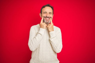 Izole kırmızı arka plan üzerinde gri saçlı Yakışıklı orta yaş yaşlı adam açık ağız ile gülümseyen, parmakları işaret ve neşeli gülümseme zorluyor