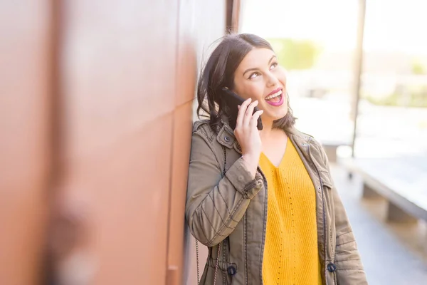 Gyönyörű fiatal nő mosolyogva pozitív hívás segítségével smarpthone — Stock Fotó