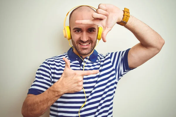 Joven Escuchando Música Usando Auriculares Amarillos Sobre Fondo Aislado Sonriendo —  Fotos de Stock