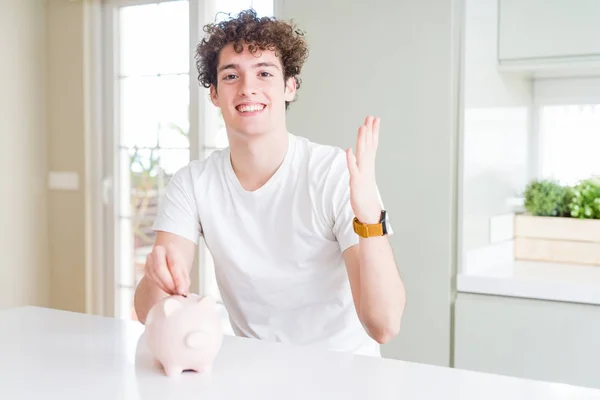 Νέος Άνθρωπος Επενδύοντας Χρήματα Χρησιμοποιώντας Κουμπαράς Στο Σπίτι Πολύ Χαρούμενος — Φωτογραφία Αρχείου