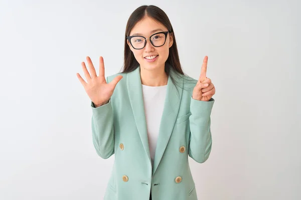 中国のビジネスウーマンは 自信を持って幸せに微笑みながら 6番の指を見せ 指で指を上げる孤立した白い背景の上にエレガントなジャケットとメガネを身に着けている — ストック写真