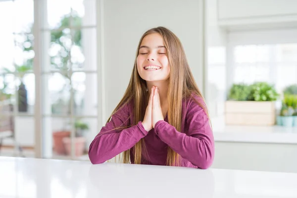 白いテーブルの上の美しい若い女の子は 自信を持って許しを求めて手で祈ります — ストック写真