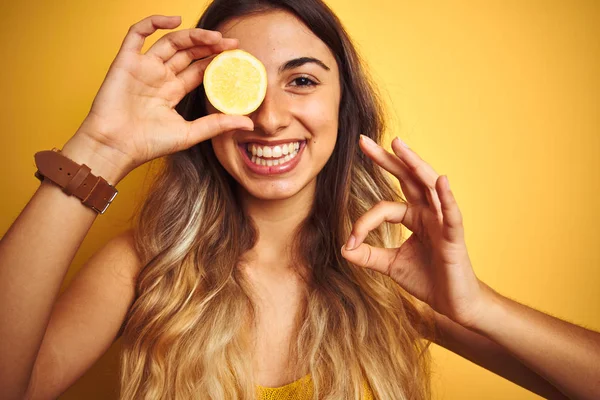 Jovem Mulher Bonita Segurando Limão Olho Sobre Fundo Isolado Amarelo — Fotografia de Stock