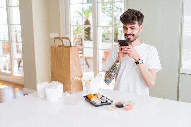 Genç adam alma fotoğraf ile Smartphone arasında Suşi Asya gıda fr