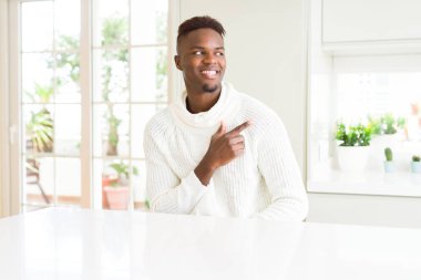 Afro-Amerikan yakışıklı beyaz tablo neşeli bir gülümseme ile el ve parmak kadar yan yüzünde mutlu ve doğal ifade ile işaret eden yüz