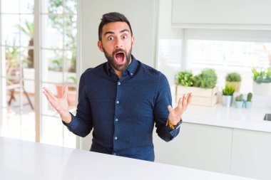 Yakışıklı İspanyol adam deli kutluyor ve kollarını kaldırdı ve açık gözleri heyecan çığlık ile başarı için hayran. Kazanan kavramı