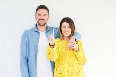 Genç güzel çift izole arka plan üzerinde togheter gösteren ve emin ve mutlu gülümseyerek parmak sayısı bir ile işaret.