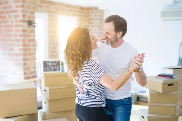 Middle age senior couple moving to a new house, dancing and smiling happy in love with apartmant