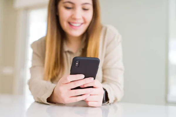 Close-up van de vrouw met behulp van smartphone en glimlachend zelfverzekerd — Stockfoto