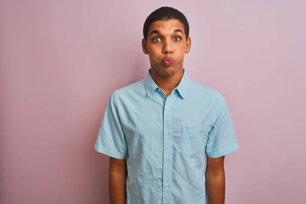 年轻的英俊阿拉伯男子穿着蓝色衬衫站在孤立的粉红色背景鼓起脸颊与滑稽的脸 嘴膨胀与空气 疯狂的表达 — 图库照片
