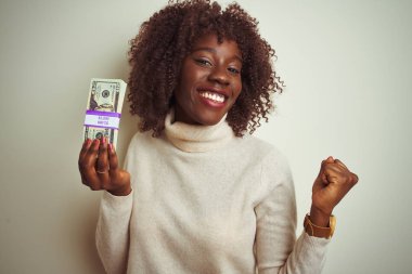 Genç afrikalı afro kadın izole beyaz arka plan üzerinde duran dolar tutan gurur çığlık ve zafer ve başarı çok heyecanlı kutluyor, duygu tezahürat