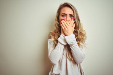 Beyaz izole arka plan üzerinde duran genç güzel kadın hata için elleri ile ağız kapsayan şok. Gizli kavram.