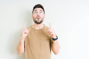 Yakışıklı delikanlı izole arka plan üzerinden hayran ve yukarıya bakıp parmakları ile işaret şaşırttı ve silah kaldırdı.